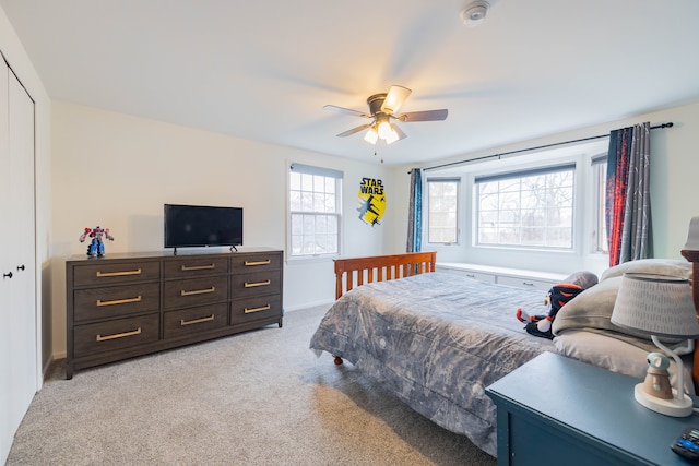 carpeted bedroom featuring ceiling fan and a closet