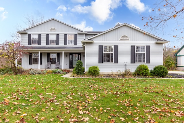 view of front property featuring covered porch and a front lawn