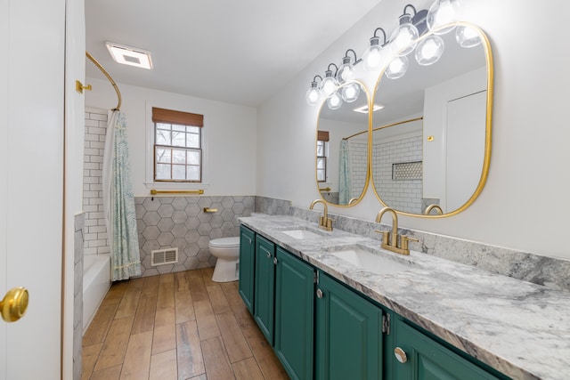 full bathroom with vanity, shower / bath combination with curtain, hardwood / wood-style flooring, toilet, and tile walls