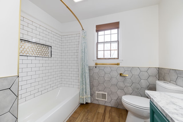 full bathroom featuring vanity, toilet, shower / bath combo, and tile walls