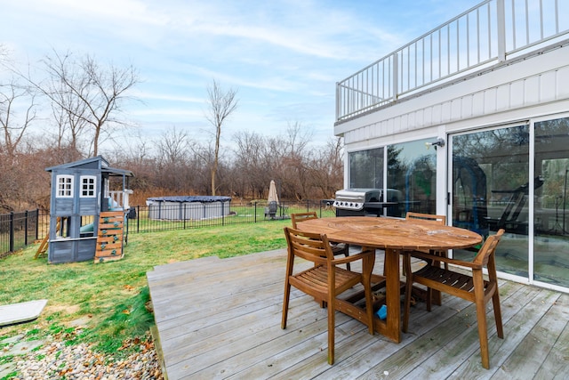 wooden deck featuring a yard, a playground, and a grill