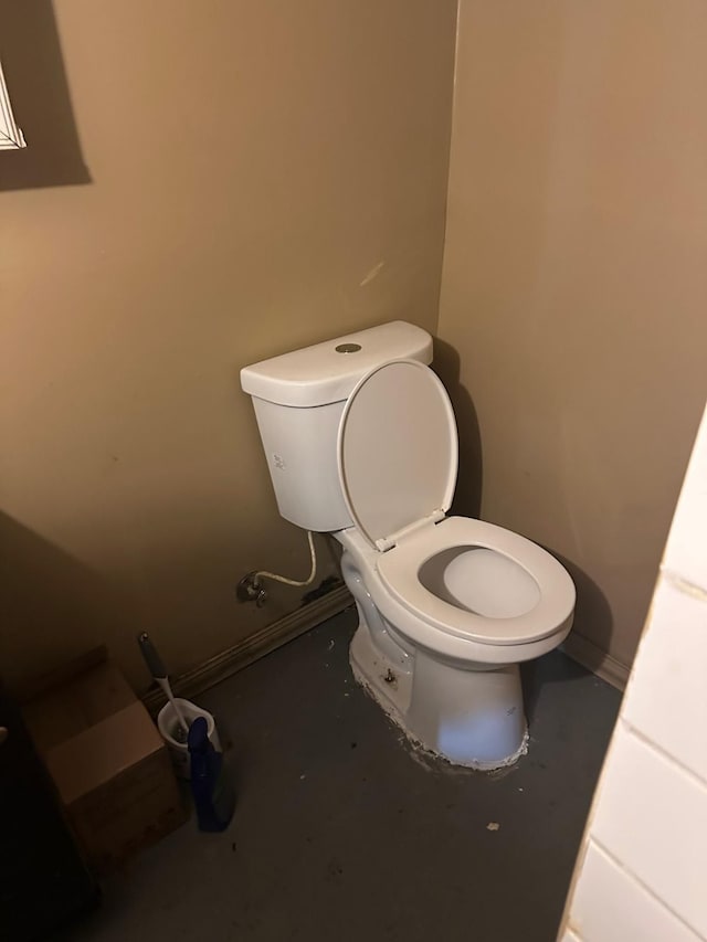 bathroom featuring toilet and concrete flooring