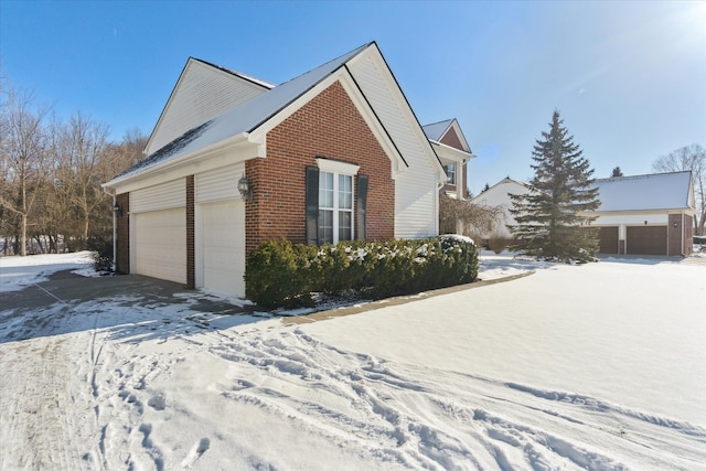 view of snow covered exterior with a garage