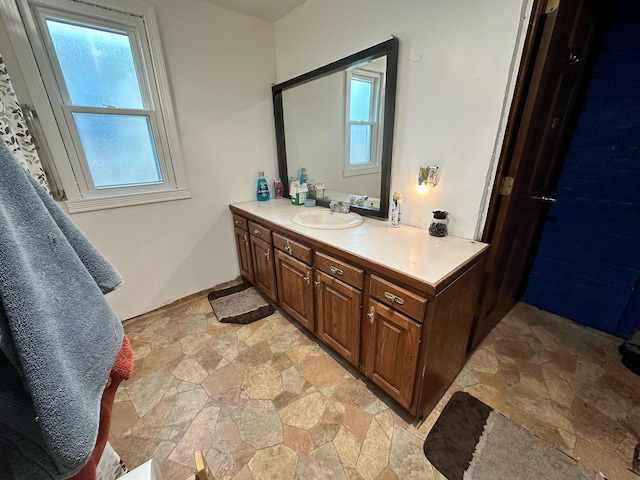 bathroom with stone finish floor and vanity