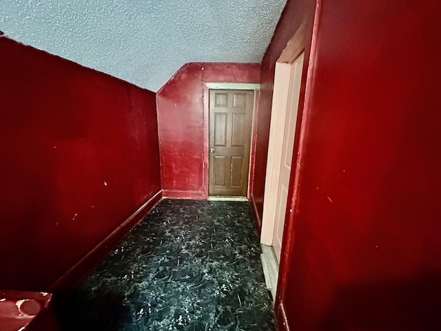 additional living space with a textured ceiling and baseboards