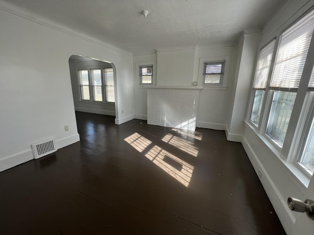 empty room featuring a textured ceiling and dark wood-type flooring