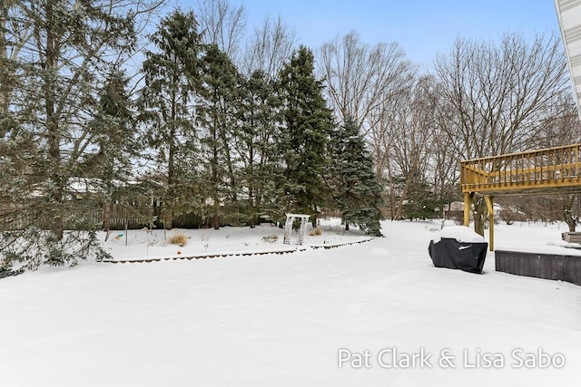 yard covered in snow featuring a deck