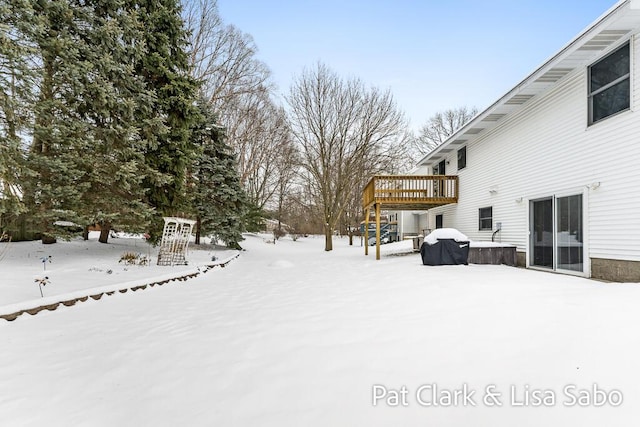 yard covered in snow with a deck