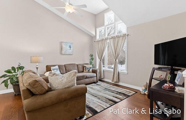 living room with a towering ceiling, ceiling fan, and dark wood-type flooring