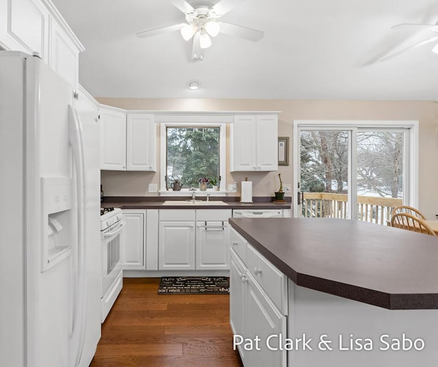 kitchen featuring white appliances, white cabinetry, and sink