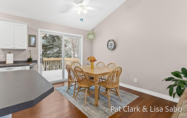 dining space with ceiling fan, dark hardwood / wood-style floors, and vaulted ceiling