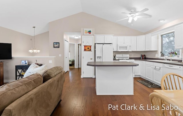 kitchen featuring white appliances, hanging light fixtures, vaulted ceiling, a kitchen island, and white cabinetry