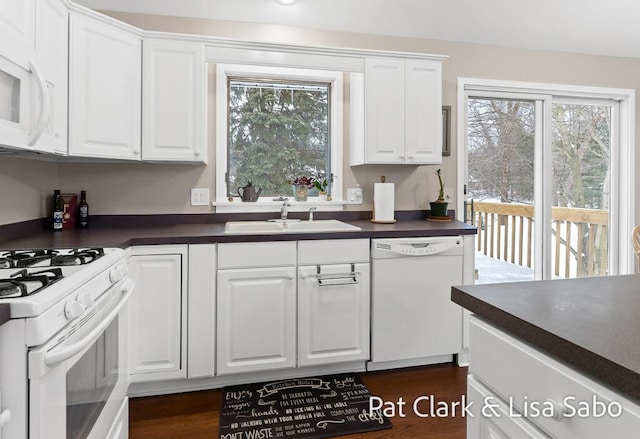 kitchen with white cabinets, white appliances, plenty of natural light, and sink