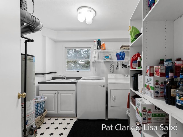 laundry area featuring cabinets, sink, gas water heater, and washing machine and clothes dryer