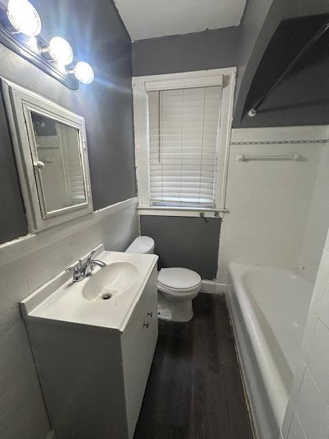 13523 Santa Rosa Dr, Detroit, MI 48238 - bathroom featuring wood finished floors, vanity, toilet, and a tub