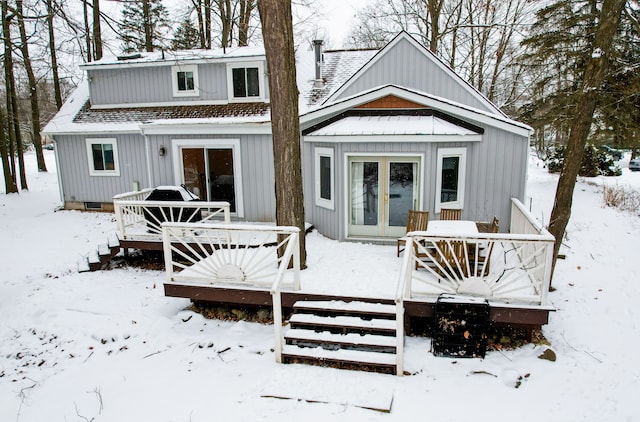 snow covered rear of property with a wooden deck