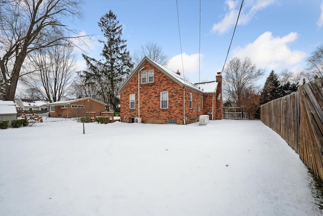 view of snow covered back of property