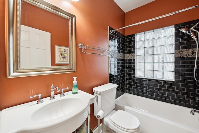 full bathroom with sink, tiled shower / bath combo, and toilet