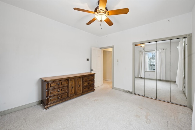 carpeted bedroom featuring ceiling fan and a closet