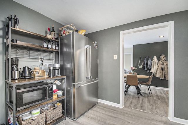 bar featuring light wood-type flooring and high quality fridge