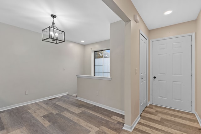 entryway featuring hardwood / wood-style flooring and a notable chandelier