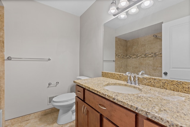 bathroom with tile patterned flooring, vanity, and toilet