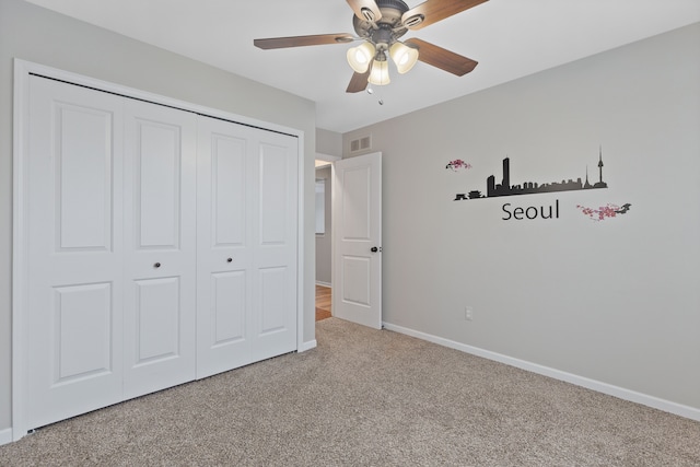 unfurnished bedroom featuring carpet, a closet, and ceiling fan