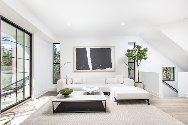 living room featuring vaulted ceiling and light wood-type flooring