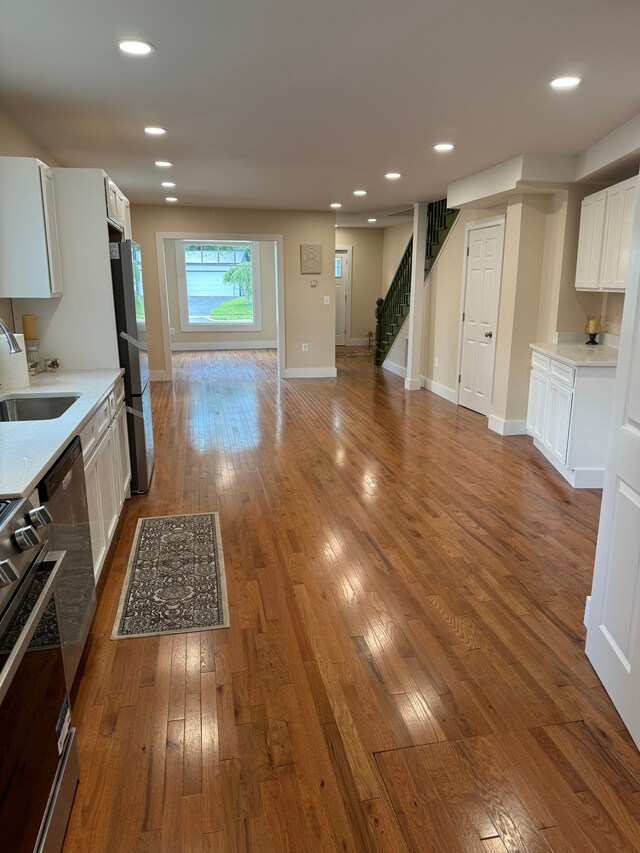 kitchen featuring sink, dark hardwood / wood-style flooring, white cabinetry, and appliances with stainless steel finishes