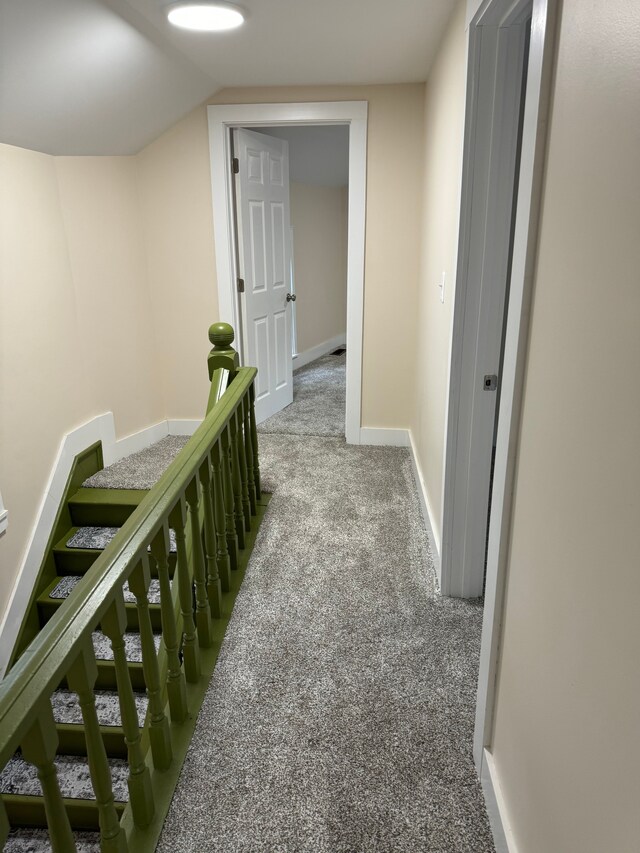 corridor with carpet and lofted ceiling