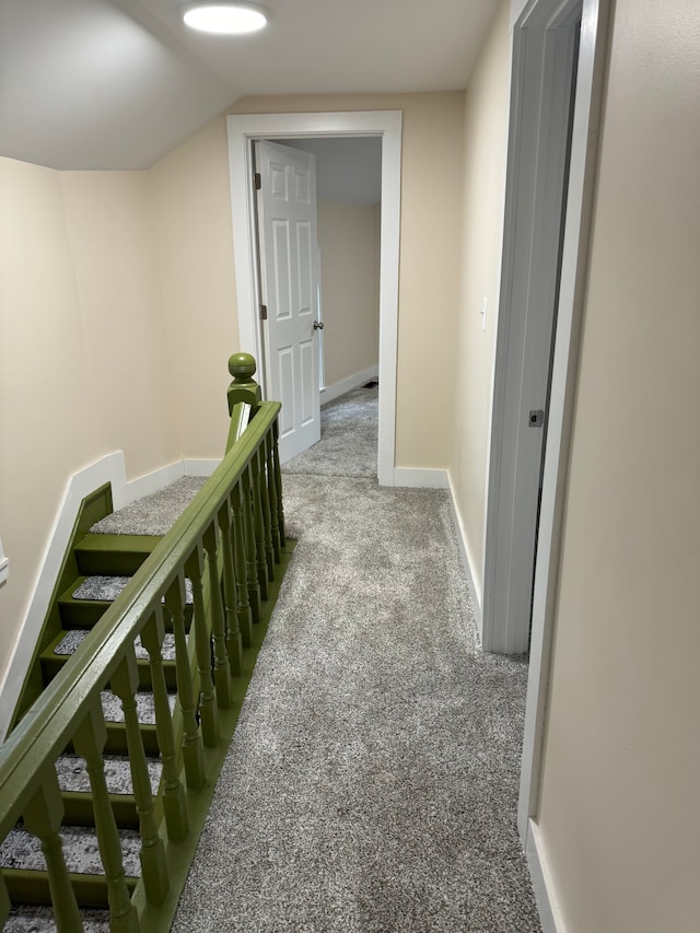 hallway with vaulted ceiling and carpet