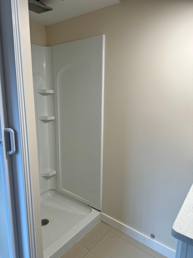 bathroom featuring vanity, a shower, and tile patterned flooring