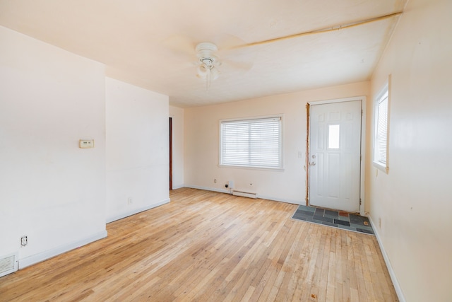 entrance foyer with ceiling fan, light hardwood / wood-style flooring, and a baseboard heating unit