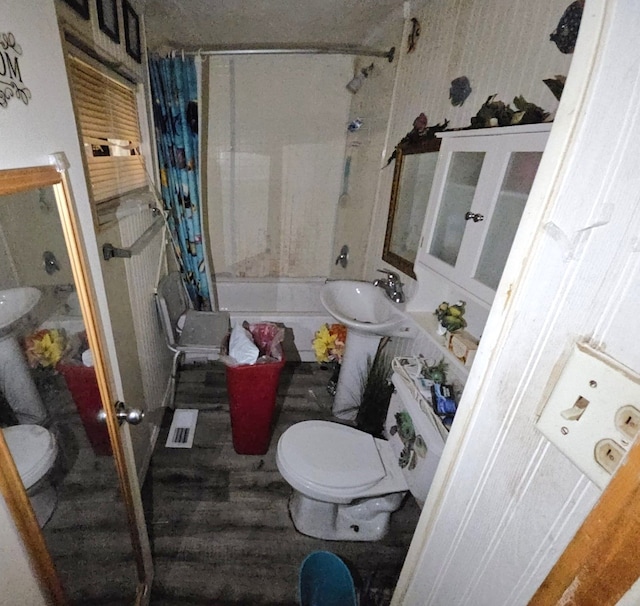 bathroom with toilet, wood-type flooring, and shower / tub combo with curtain