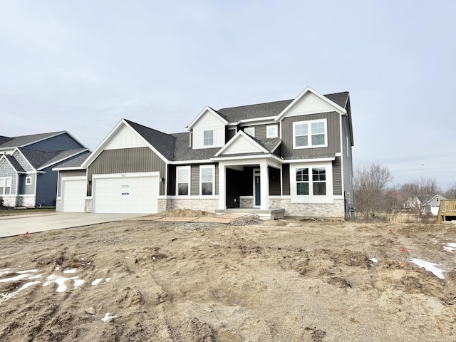 view of front of home with a shingled roof, concrete driveway, an attached garage, board and batten siding, and stone siding