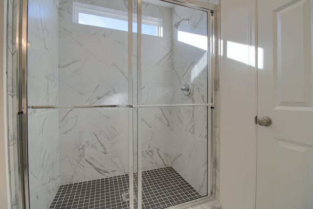 bathroom with a shower with door