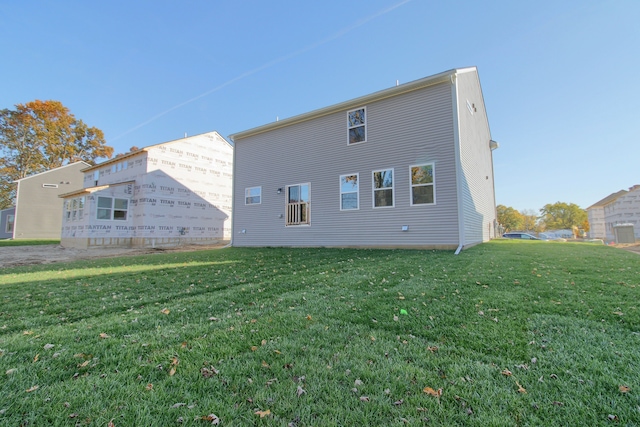 rear view of house featuring a yard