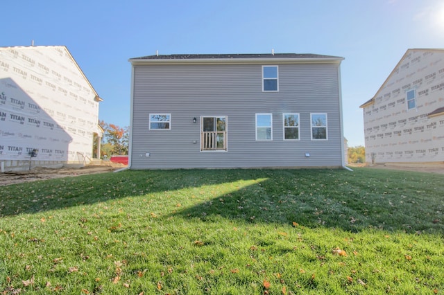 rear view of property featuring a lawn