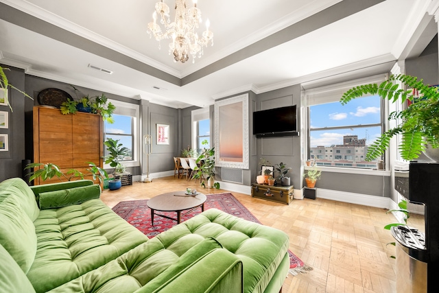 living room featuring ornamental molding, parquet floors, an inviting chandelier, and a tray ceiling