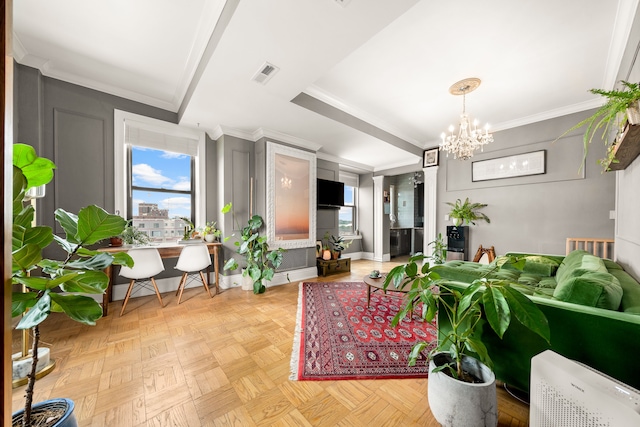 living room featuring ornamental molding, light parquet flooring, and a chandelier