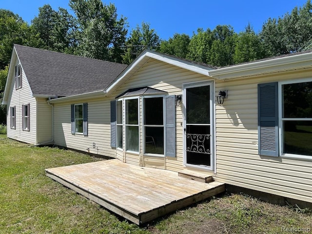 back of property with a lawn and a deck