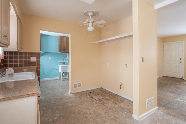 kitchen featuring ceiling fan, decorative backsplash, and sink