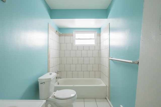 bathroom with toilet, tile patterned flooring, and tiled shower / bath