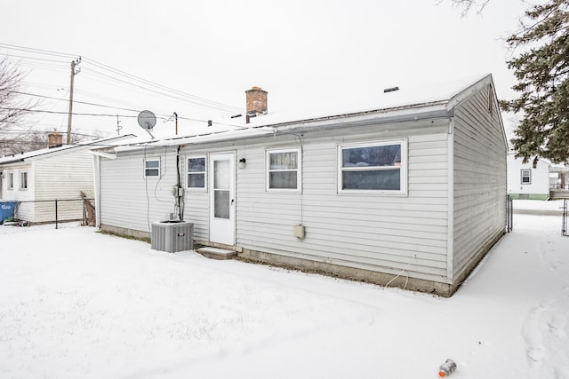 snow covered back of property with central AC unit