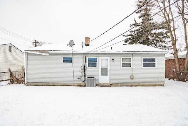 snow covered property featuring central AC