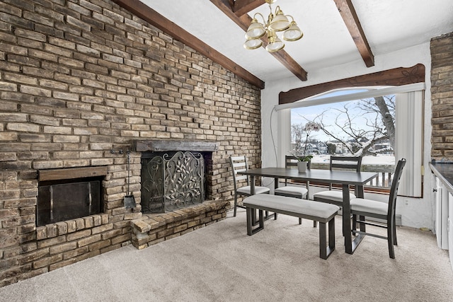 dining room featuring beam ceiling, a chandelier, light colored carpet, and a brick fireplace