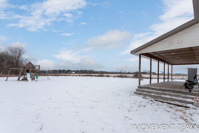 yard layered in snow with a playground