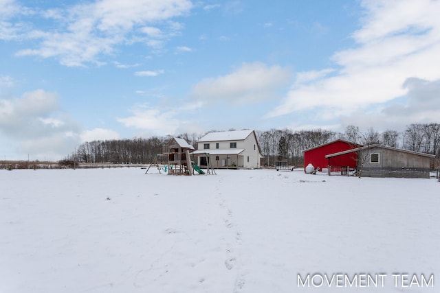 yard layered in snow with a playground