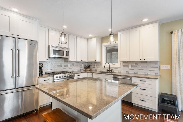 kitchen with pendant lighting, a center island, white cabinetry, and stainless steel appliances