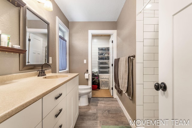 bathroom featuring toilet, vanity, and hardwood / wood-style flooring